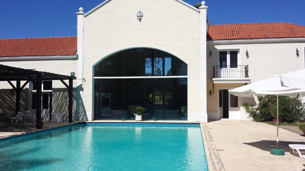 a swimming pool in front of a house at Solanas Termas de Dayman in Termas del Daymán