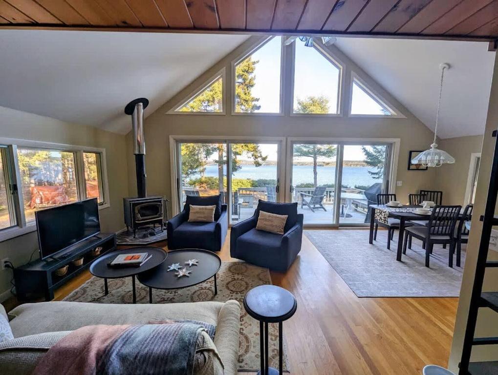 a living room with a lot of windows at Seashells on the Seashore Cottage in Hancock