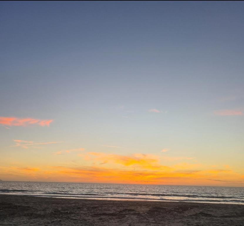 a sunset on a beach with the ocean at Albanian Dream Escape Apartment in Golem