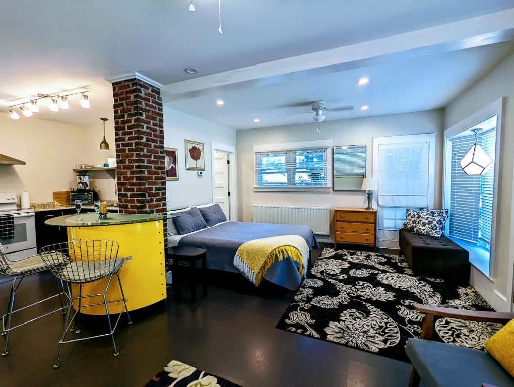 a living room with a bed and a kitchen with a table at Acadia Park Suites 1 in Southwest Harbor