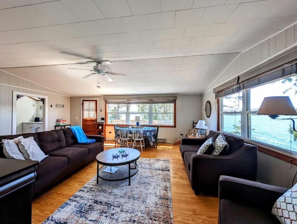 a living room with couches and a table at Lobster Pound Beach House in Hancock