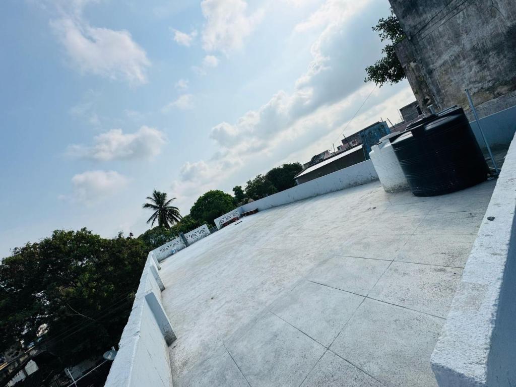 ティルヴァンナーマライにあるMURUGA Homestayのヤシの木を背景にした建物の屋根