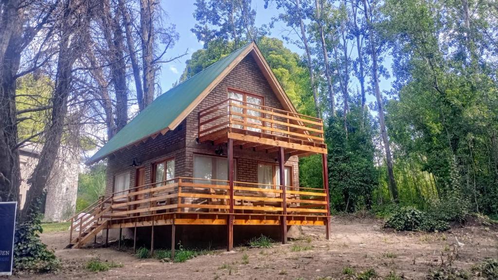 een klein huis met een groen dak in het bos bij La Rubina in Villa Ventana