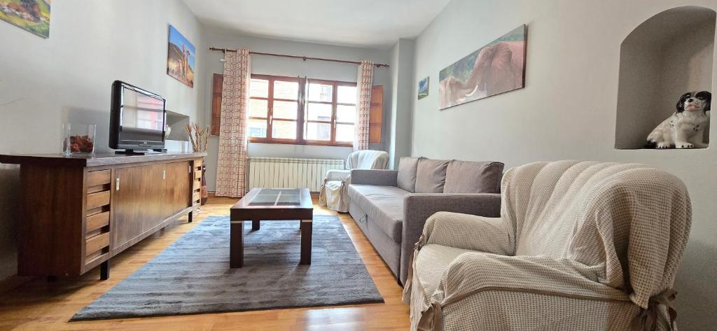 a living room with a couch and a tv at Casa Pilar, Ribadesella in Ribadesella