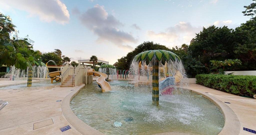 Children's water play area with fountains, slides, and shallow pools on deck.