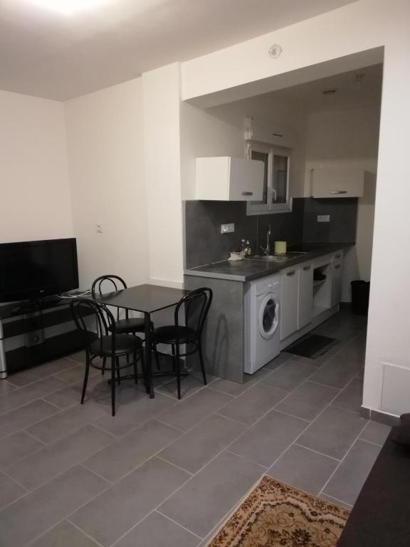 une cuisine avec une table et des chaises dans une cuisine dans l'établissement maison de ville, à La Celle-sous-Gouzon