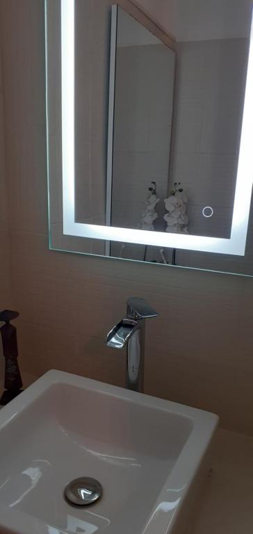 La salle de bains est pourvue d'un lavabo avec miroir et d'un robinet. dans l'établissement Le lutetia 06, à Cannes