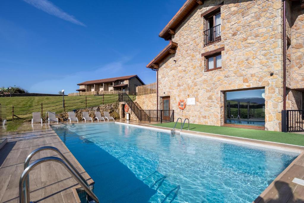 a large swimming pool in front of a stone building at Villas Spa El Mirador de Isla in Isla