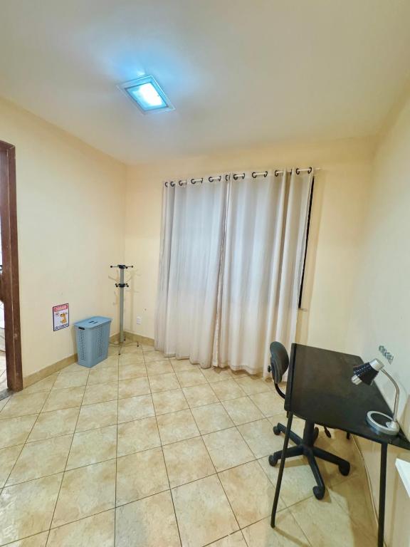 a room with a chair and a desk and a window at Casa in Belém