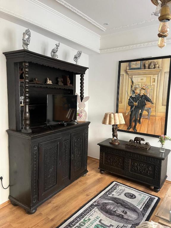 a living room with a black entertainment center and a television at Ferienwohnung 36, die etwas Andere in Quedlinburg