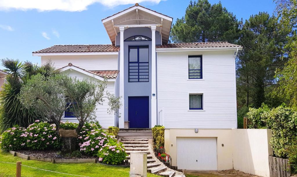 une maison blanche avec une porte bleue dans l'établissement Villa Destordeur, à Moliets-et-Maa