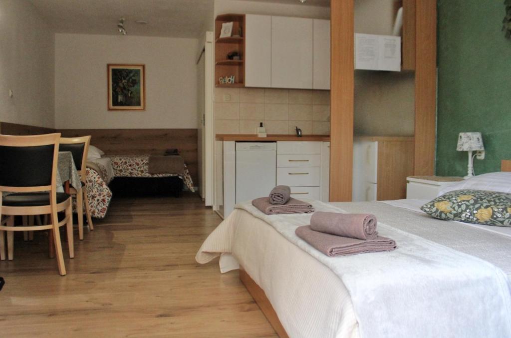 a bedroom with two beds with towels on the bed at Studio apartment Laura-spacious studio on the main beach in Makarska