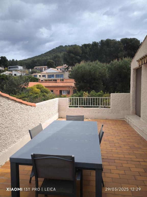 une table bleue et des chaises assises sur une terrasse dans l'établissement Studio, aux Lecques