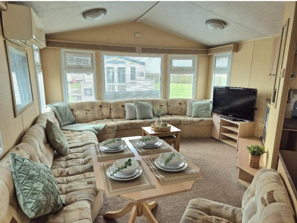 ein Wohnzimmer mit Sofa und Fernseher in der Unterkunft Meadow Lakes 64, pet friendly , WiFi & bed linen - Golden Palm Resort - Meadow Lakes Caravan & Lodge Hire in Chapel Saint Leonards