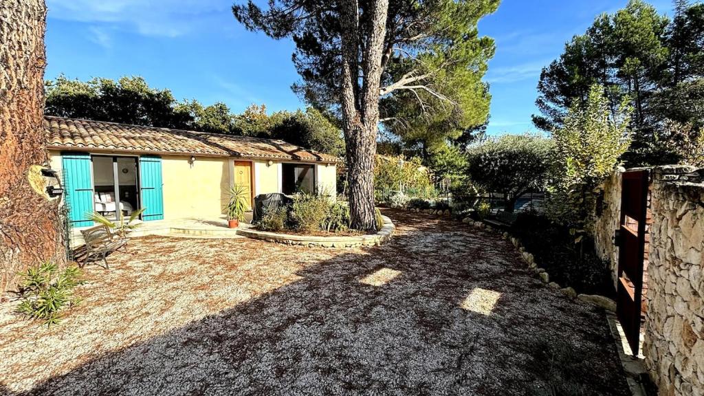 une maison avec un arbre dans la cour dans l'établissement La maison du soleil, à Mazan