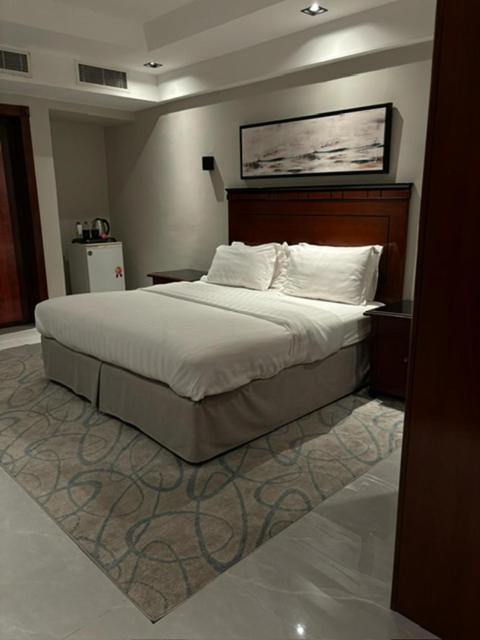 a bedroom with a large bed with white sheets and pillows at ديباج للشقق المخدومة in Dammam