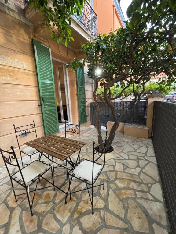 une table et des chaises et un arbre sur une terrasse dans l'établissement Lemon Tree, à Cap d'Ail