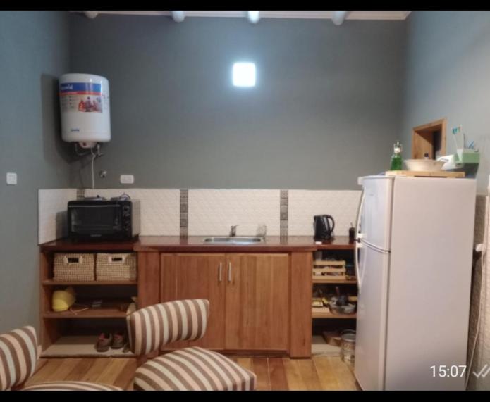 Una cocina con un refrigerador blanco y un fregadero. en Lamora, en La Criolla