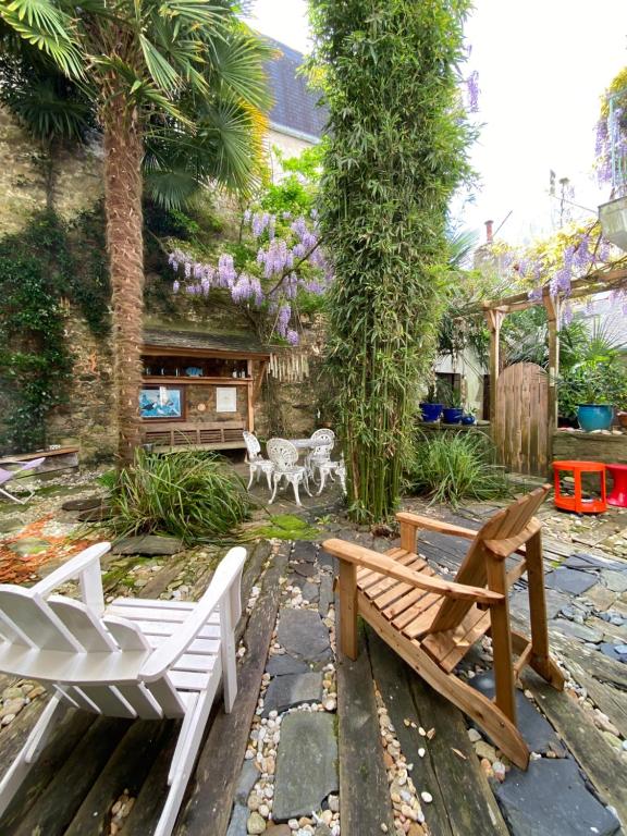 a garden with two benches and a table and chairs at Jardin paisible en centre-ville in Auray