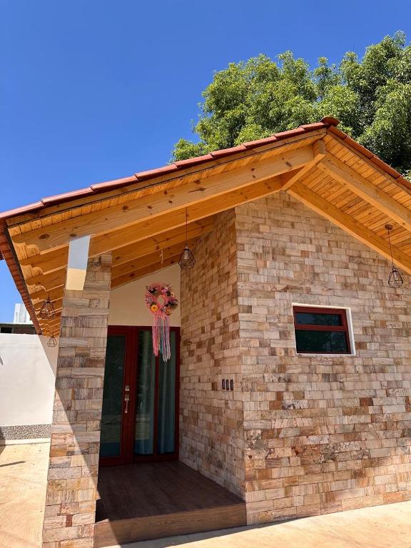 a brick building with a wooden roof and a porch at Cabaña para pareja con Jacuzzi in Huasca de Ocampo