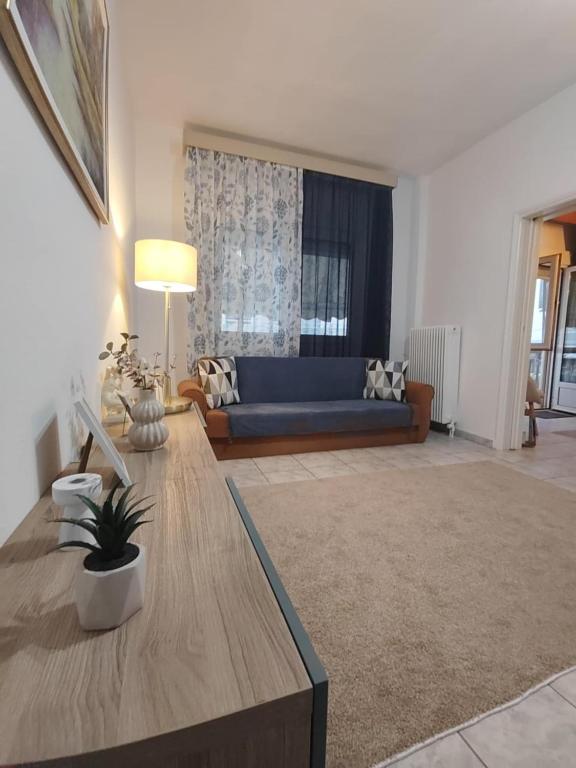 a living room with a blue couch and a table at HARBOR house in Kavála