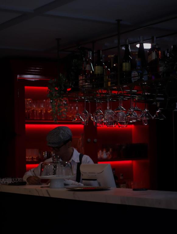 Un hombre sentado en una mesa en un bar con una computadora portátil. en Hotel Helene, en Medellín