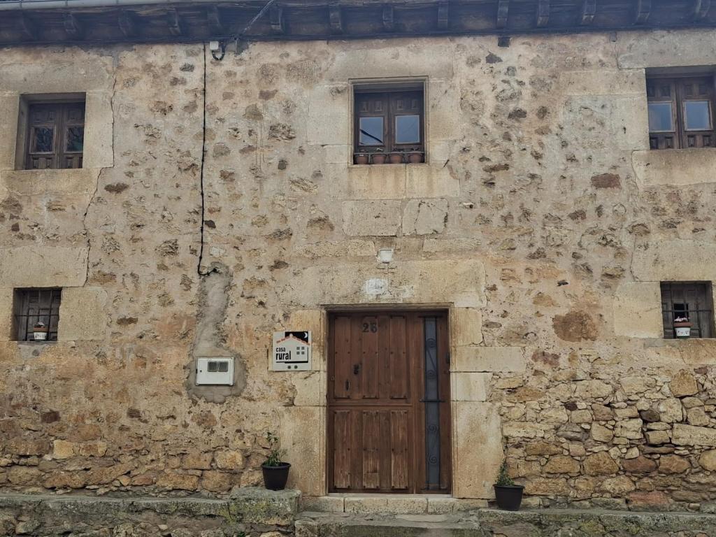 an old stone building with a wooden door at Casa Rural Kristina 2 Estrellas in Retuerta
