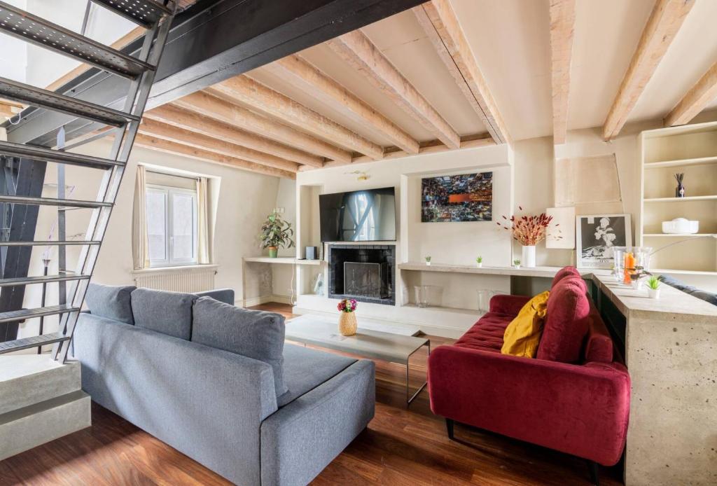 un salon avec deux canapés et une cheminée dans l'établissement Appartement 3 Pieces Hôtel de Ville Paris, à Paris