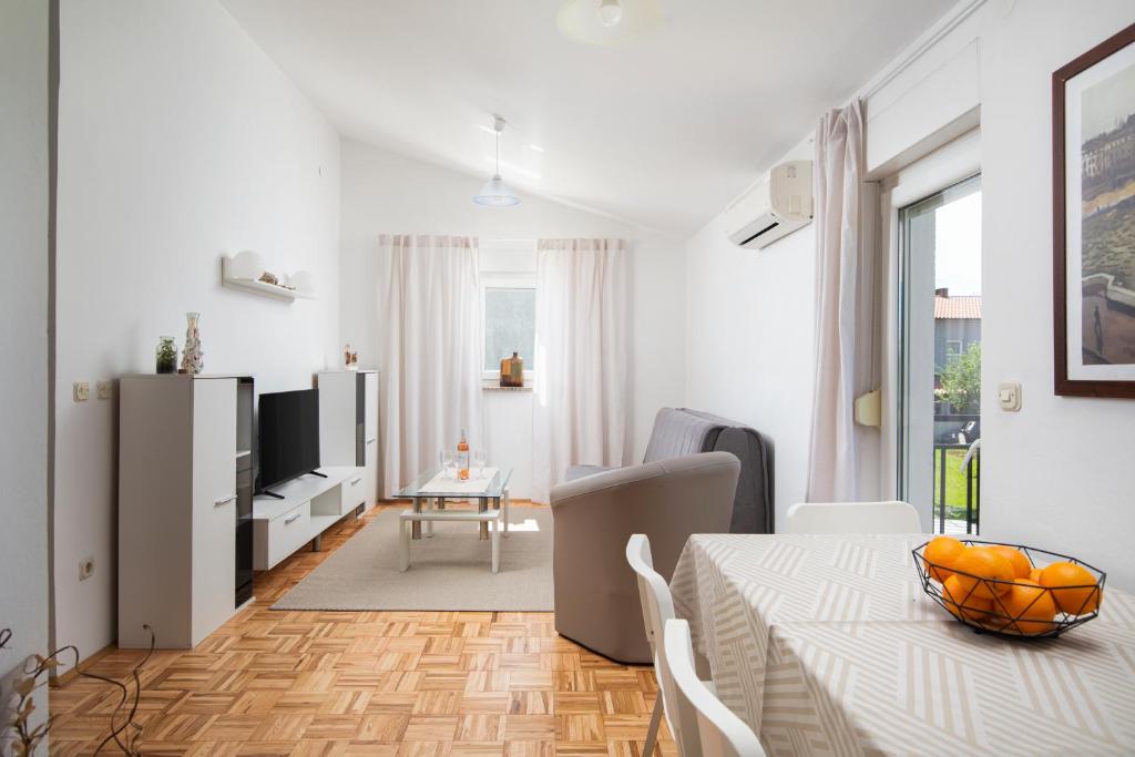 un soggiorno bianco con tavolo e sala da pranzo di Countryside apartment manu a Pola