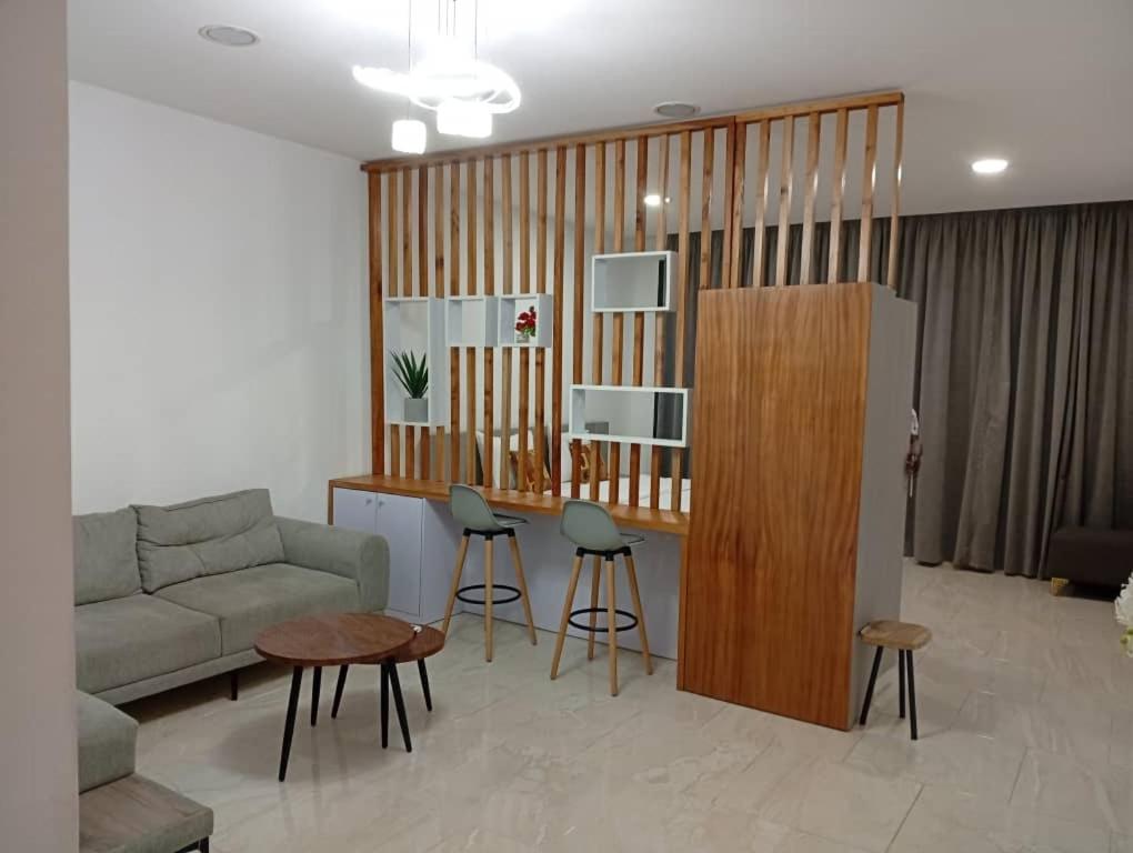 sala de estar con sofá y bar con taburetes en Bark luxury apartments Abidjan Attoban 2, en Abiyán