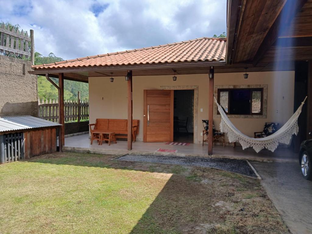 una casa con portico e amaca in cortile di Casa Visconde 2 a Visconde De Maua