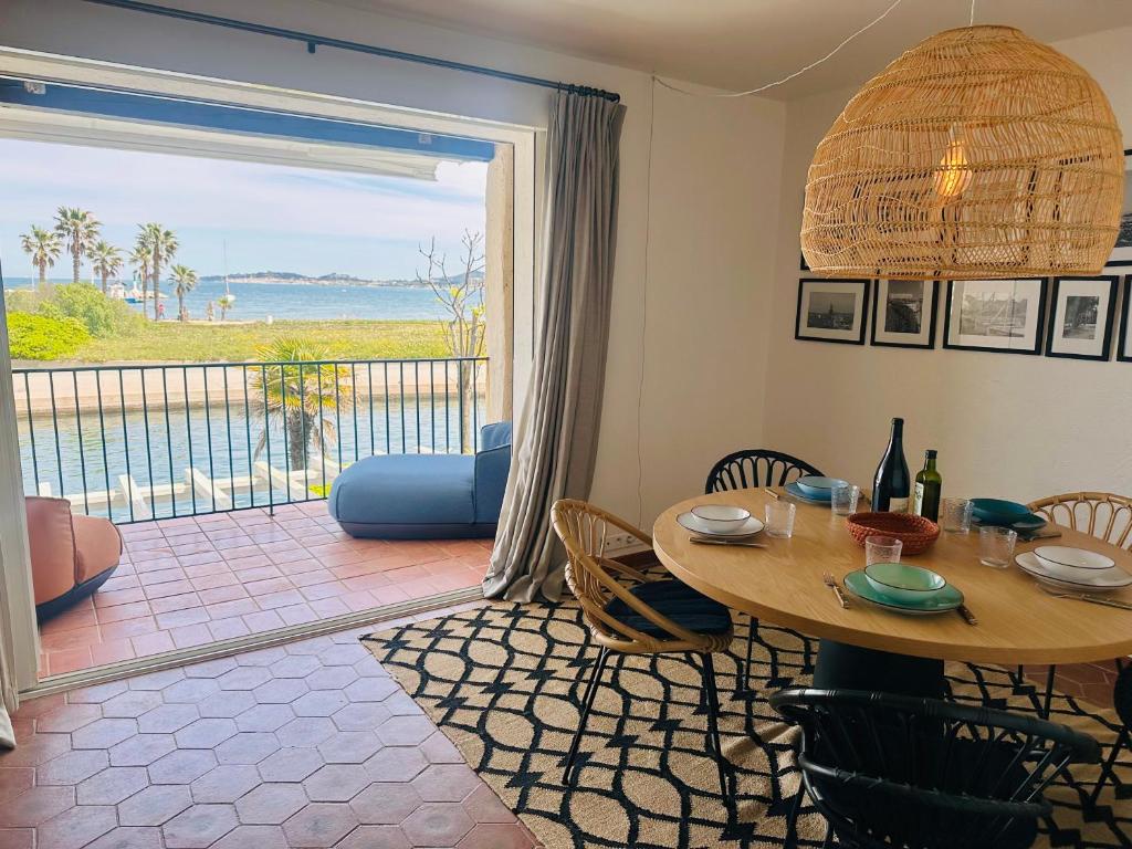une salle à manger avec une table et une vue sur l'océan dans l'établissement La Plage Grand Appt vue mer, à Grimaud