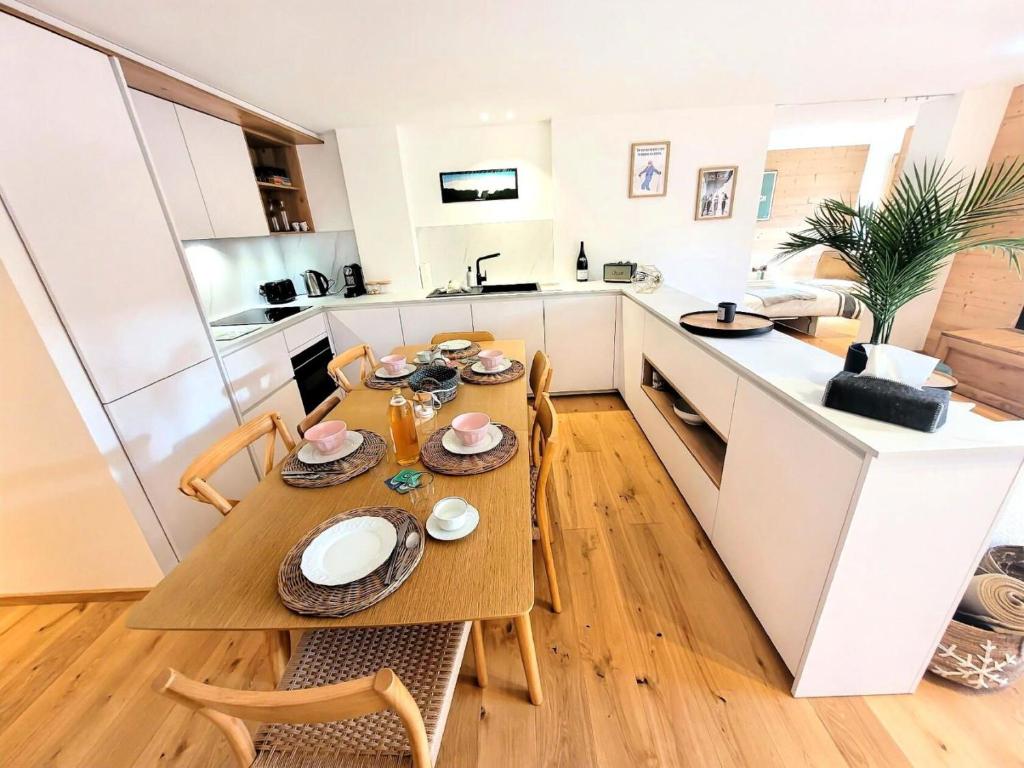 une cuisine et une salle à manger avec une table et des chaises dans l'établissement Résidence Flocon Bleu - Un cocon de standing au cœur des Gets MAE-4601, aux Gets
