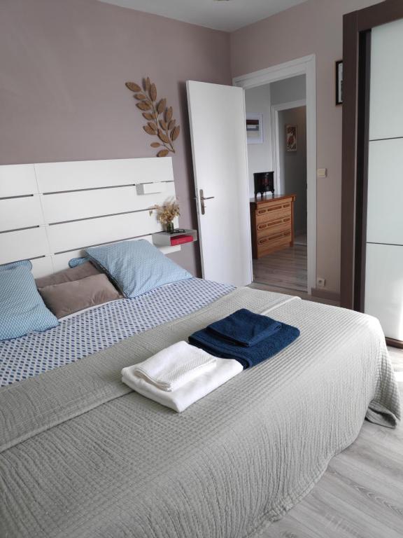 a bedroom with a large bed with a blue blanket on it at Kastell-Mor 2 chambre d'hôtes à Santec in Santec