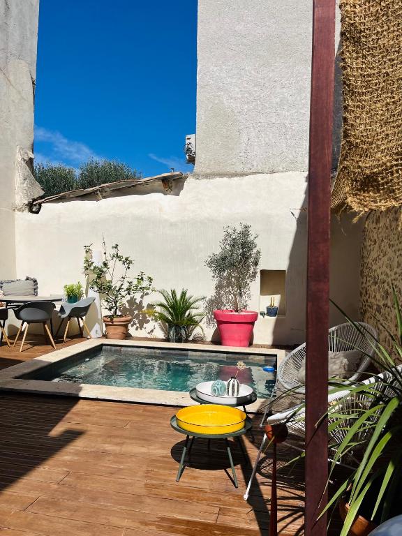une cour avec une piscine dotée d'une table et de chaises dans l'établissement Maison de ville avec piscine, à Châteaurenard