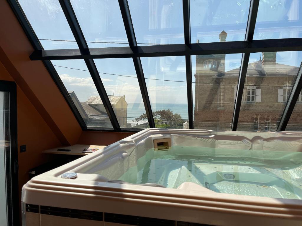 Cette chambre dispose d'un bain à remous et d'une grande fenêtre. dans l'établissement Les Tamaris - Grande Maison de Plage - Jacuzzi, à Carolles