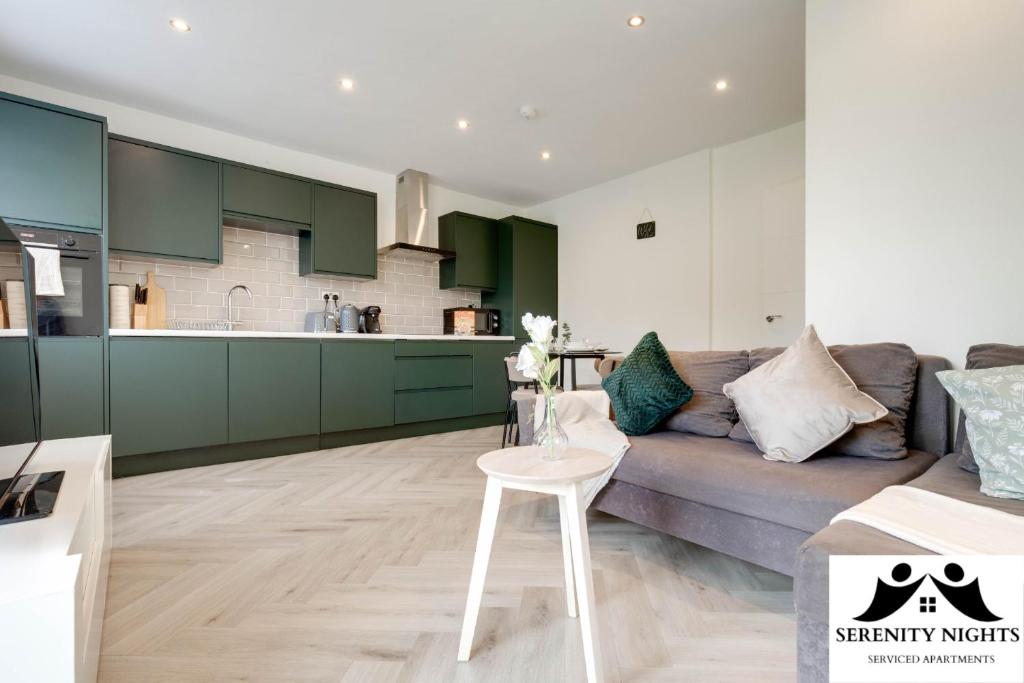 a living room and kitchen with green cabinets and a couch at Modern 1 bedroom apartment in South Croydon in Croydon