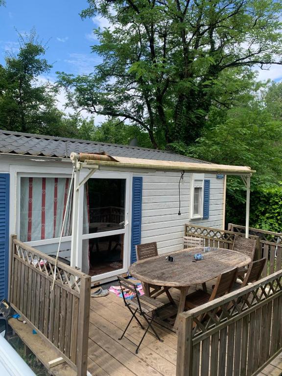 une terrasse avec une table et une maison dans l'établissement Mobilhome Destinea 6 - 7 personnes, à Saint-Thomas-en-Royans