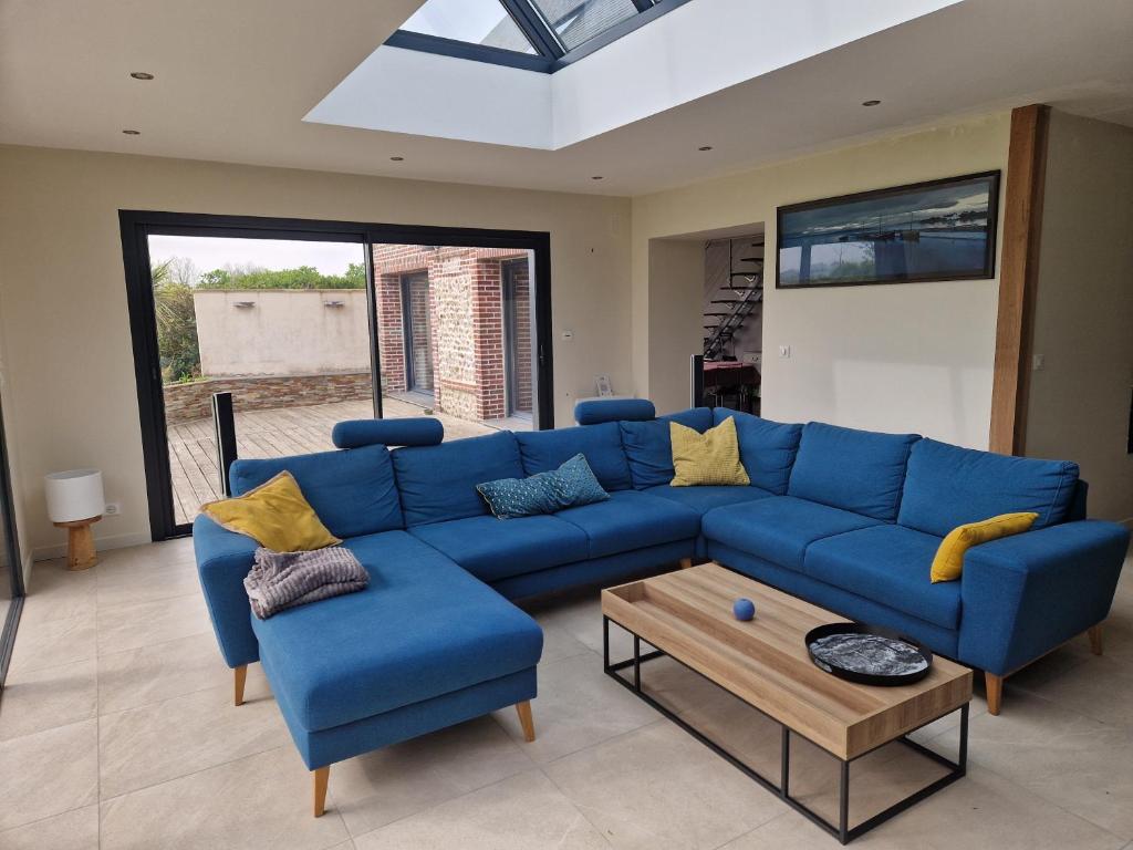 un canapé bleu et deux chaises dans un salon dans l'établissement La maison des Ifs, à Tourville-les-Ifs