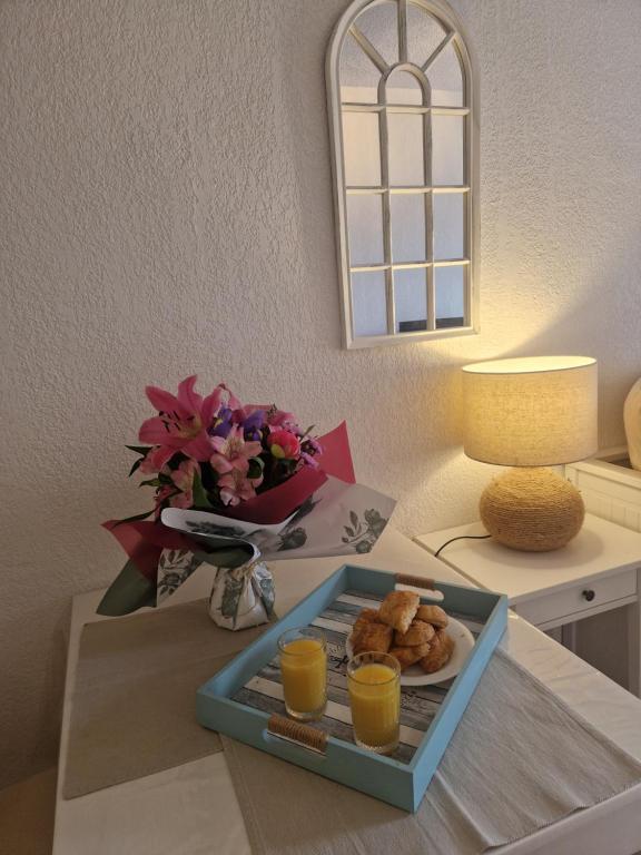 stół z tacą z jedzeniem i sokiem pomarańczowym w obiekcie Sanary soleil et douceur IV w mieście Sanary-sur-Mer
