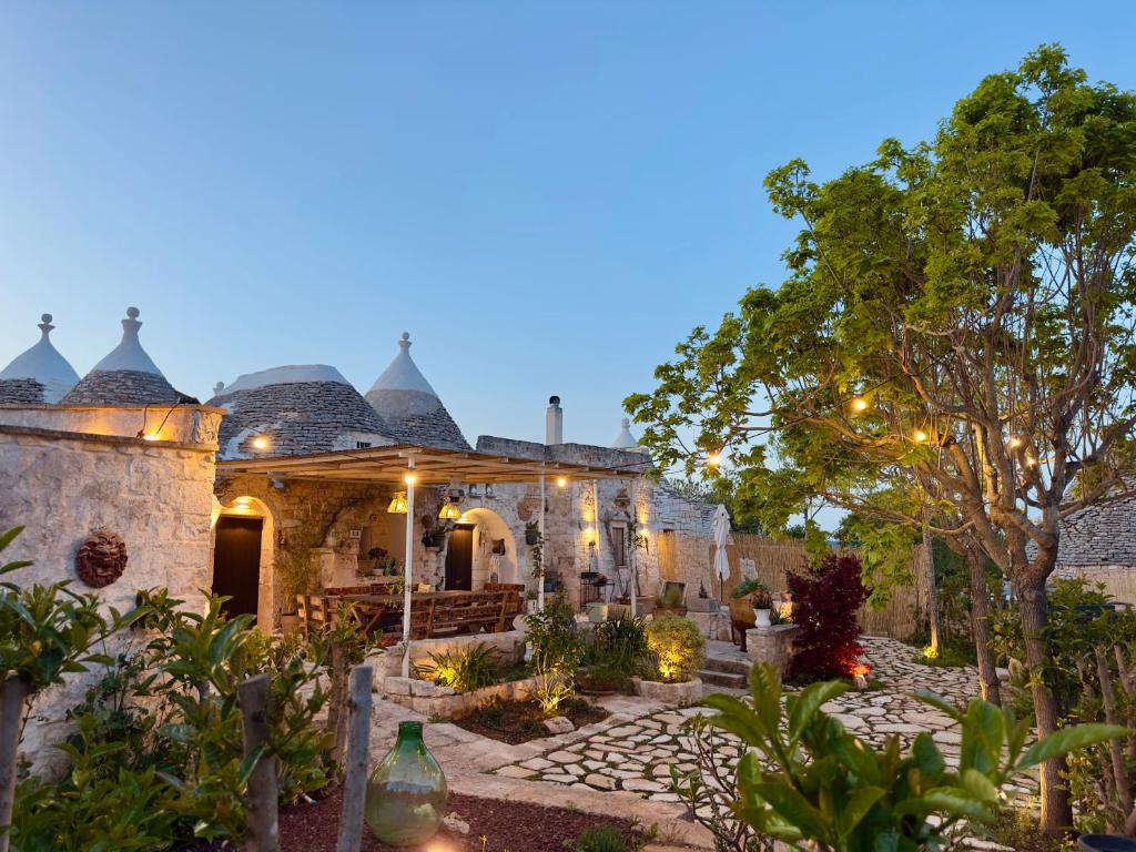 an exterior view of a house with a garden at Sto al Trullo - Historic Trullo with Private Jacuzzi and Sauna in Martina Franca