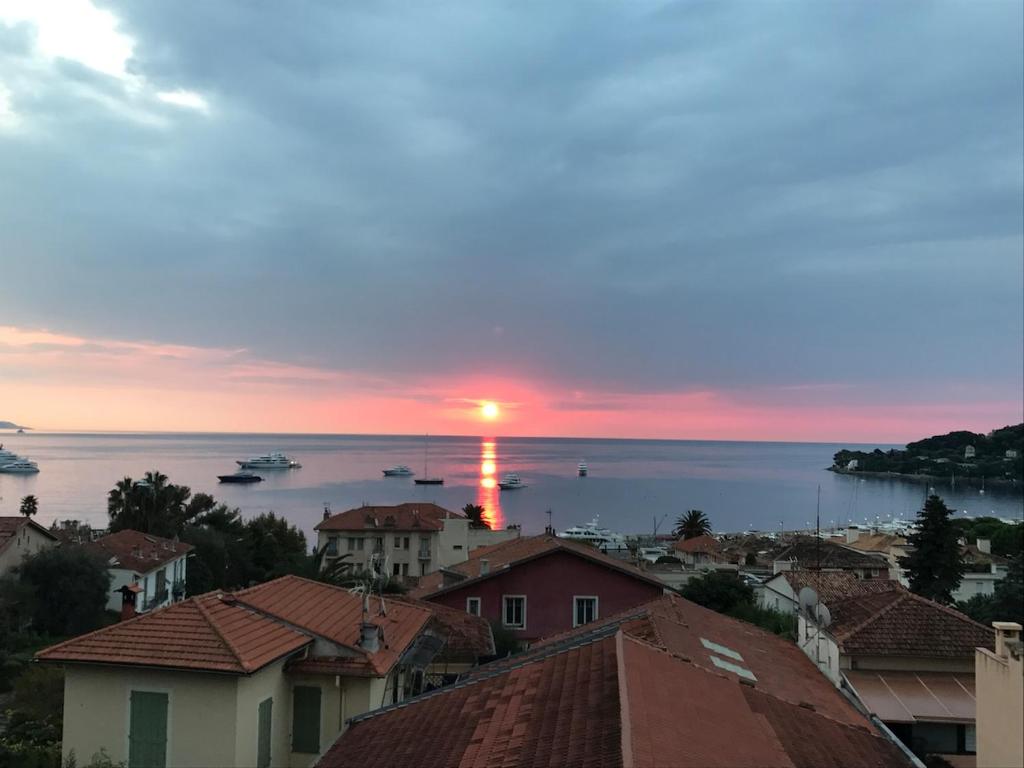 un coucher de soleil sur une ville avec des bateaux dans l'eau dans l'établissement Suggestivo appartamento, à Saint-Jean-Cap-Ferrat