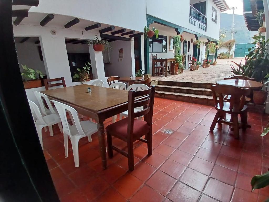 ein Holztisch und Stühle auf einer Terrasse in der Unterkunft HOTEL El CORZO DE LA VILLA in Villa de Leyva
