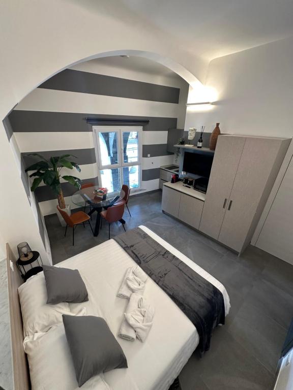 a bedroom with a large bed and a dining room at Suite degli Archi - Luxury Suites fronte Acquario Porto Antico in Genoa