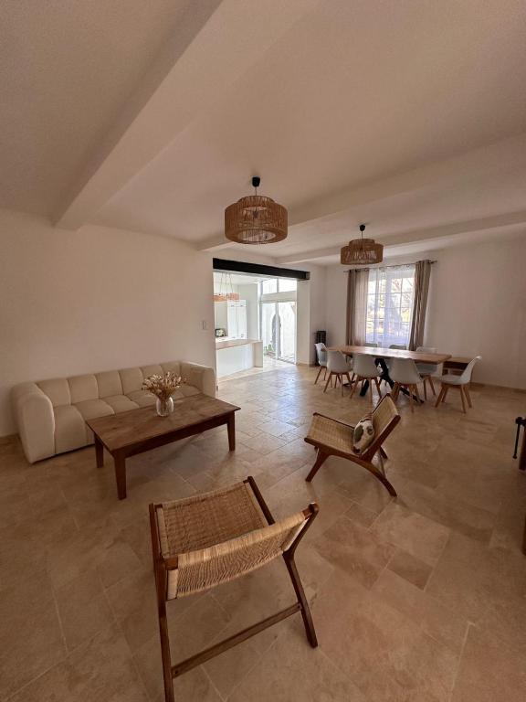 un salon avec un canapé et une table dans l'établissement Maison de charme Piscine & grand jardin, à Travaillan