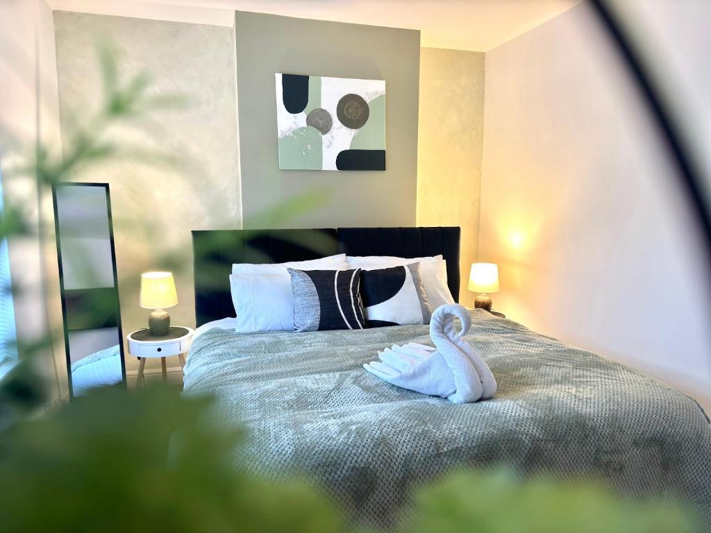 ein Schwanenhandtuch auf einem Bett in einem Schlafzimmer in der Unterkunft 4 Bed Home Northampton, FreeParking, Superfast WiFi, 5TVs in Northampton