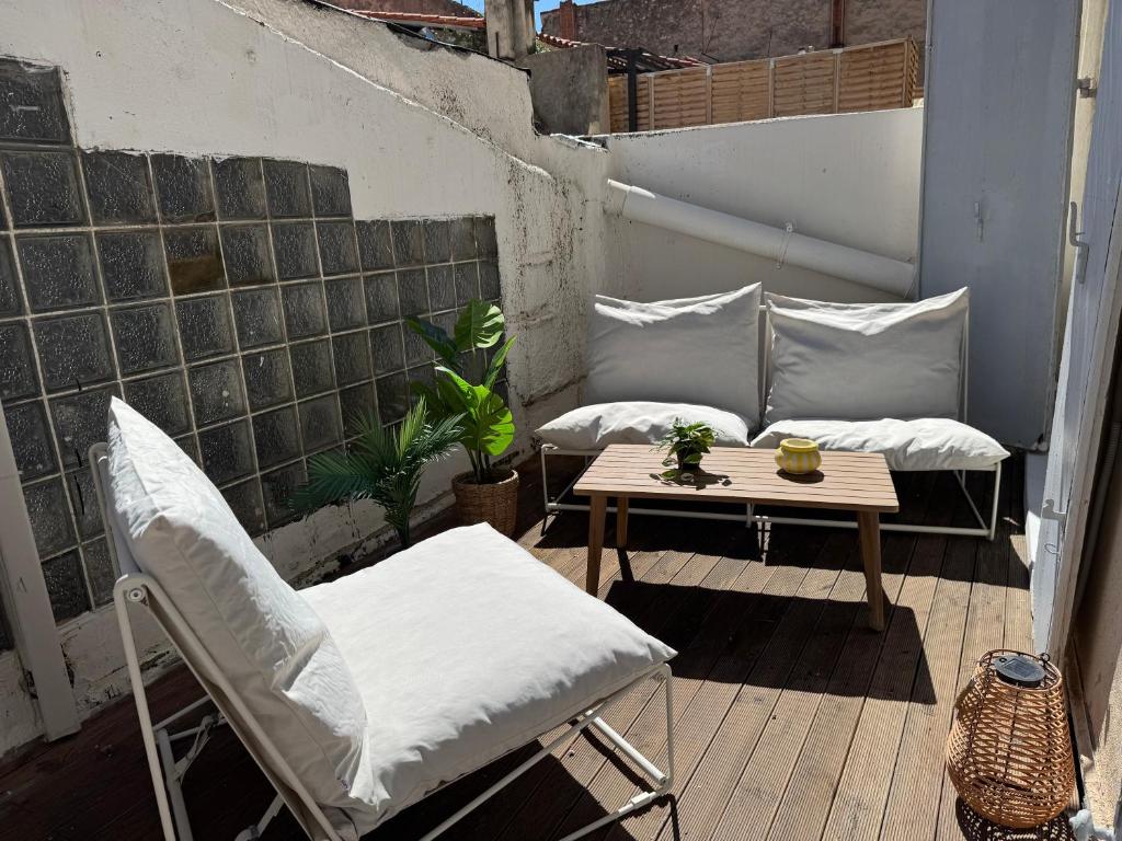 un patio avec deux chaises et une table sur un balcon dans l'établissement La Kasbah - Terrasse, Clim - 8p, à Marseille
