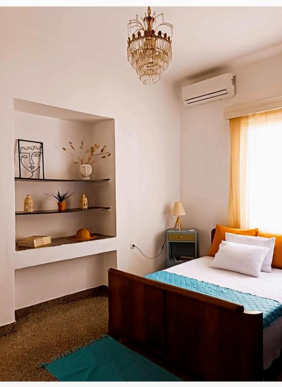a bedroom with a bed and a chandelier at The SPiTi Project 23 in Kavála