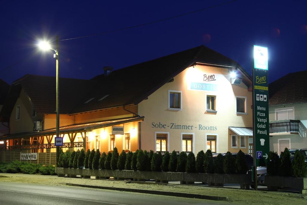 un edificio blanco con un letrero de la calle delante de él en Guesthouse Beno en Starše