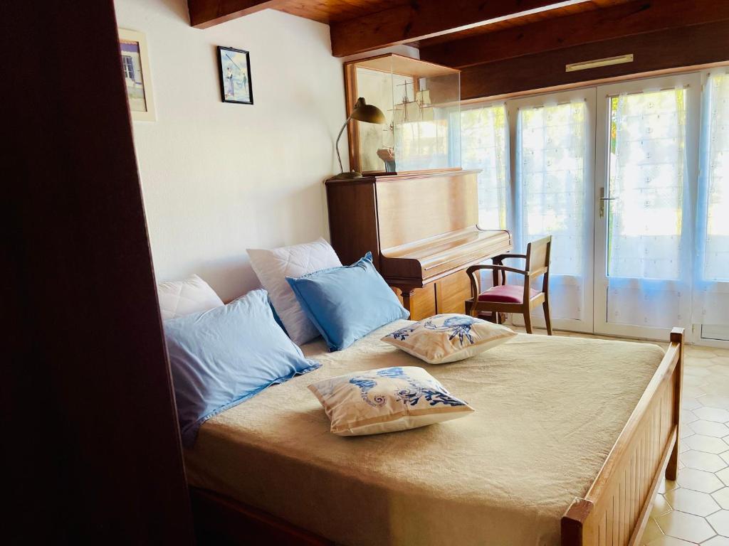1 dormitorio con 1 cama con 2 almohadas y piano en La maison des courlis, en Rivedoux-Plage